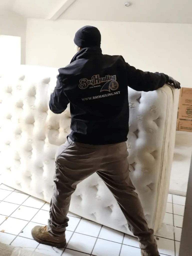 removing an old mattress from a home, ensuring professional and eco-friendly disposal